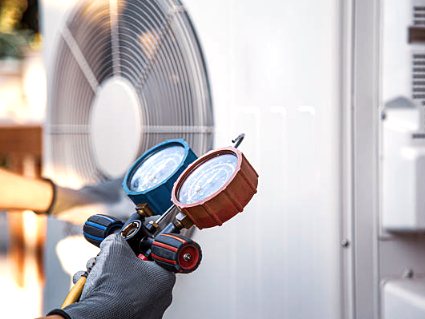 Refrigerant gauges hooked up to an outdoor AC unit