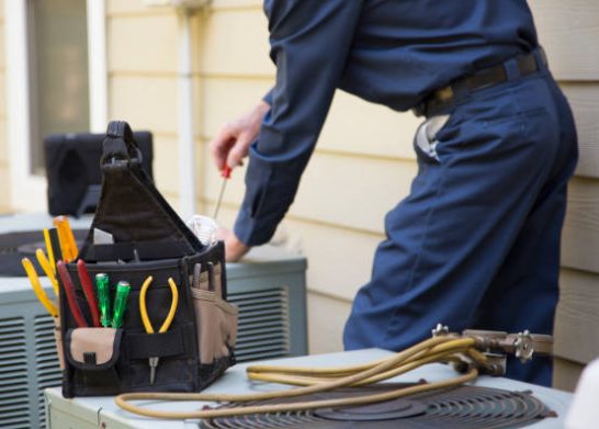 HVAC technician servicing an outdoor air conditioning unit at an Everett, WA home